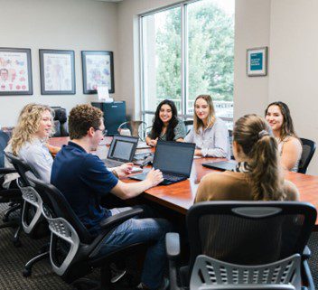 Colleagues gathered around conference room table