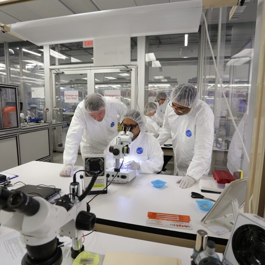 Technicians in clean room examining medical devices